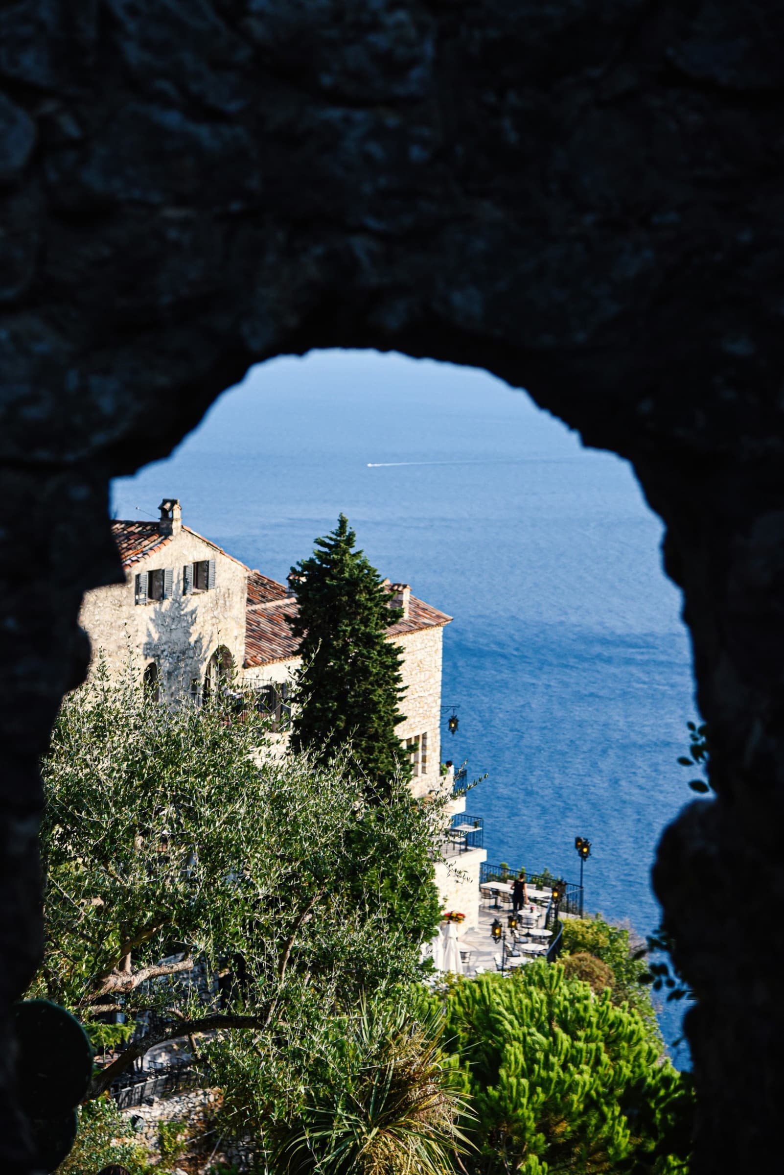 Historic stone architecture framed by an arch above the sea